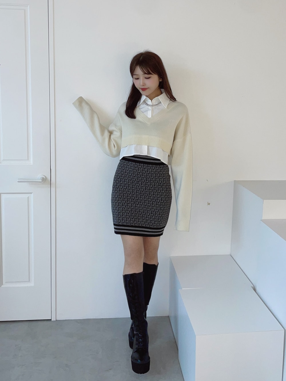 ホワイト系のシャツ/ブラウス、ブラック系のスカート、ブラック系のブーツを着用したレディースの秋コーディネートの5枚目の写真