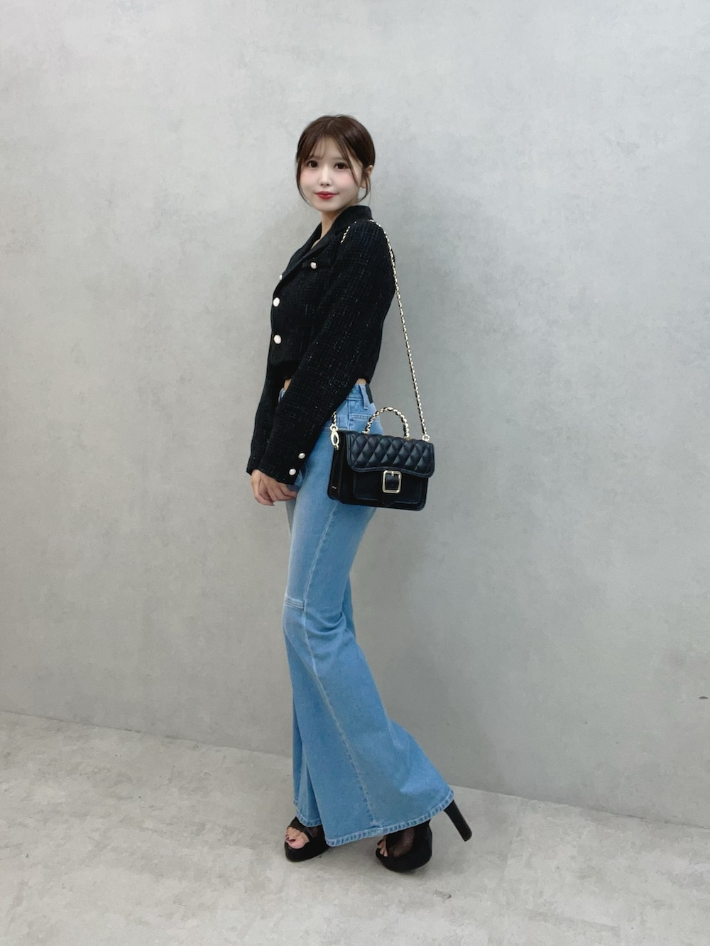 ブルー系のデニムパンツ、ブラック系のサンダル、ブラック系のテーラードジャケットを着用したレディースの秋コーディネートの5枚目の写真