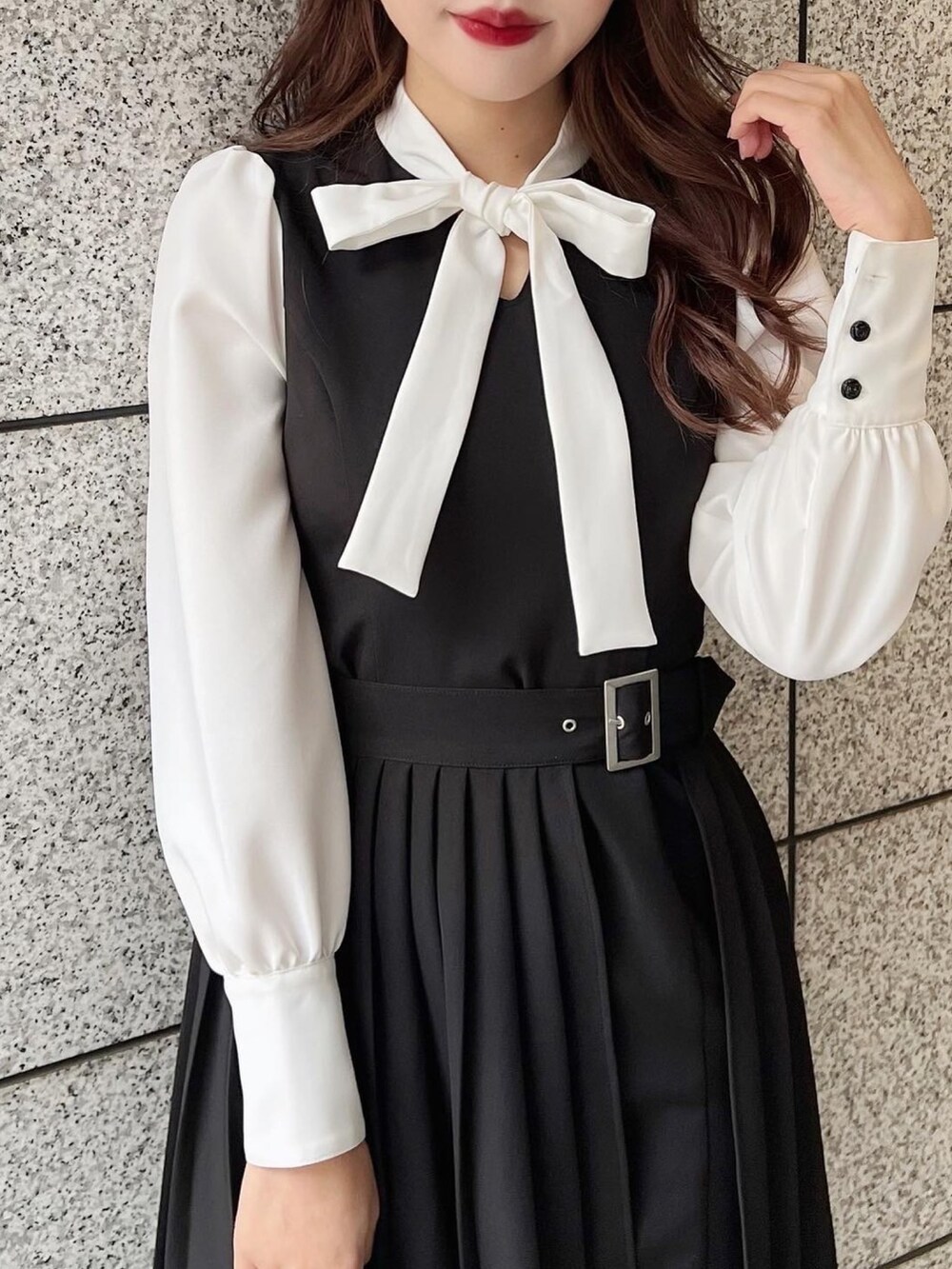 ブラック系のワンピース、ブラック系のハンドバッグ、その他のパンプスを着用したレディースの冬コーディネートの2枚目の写真