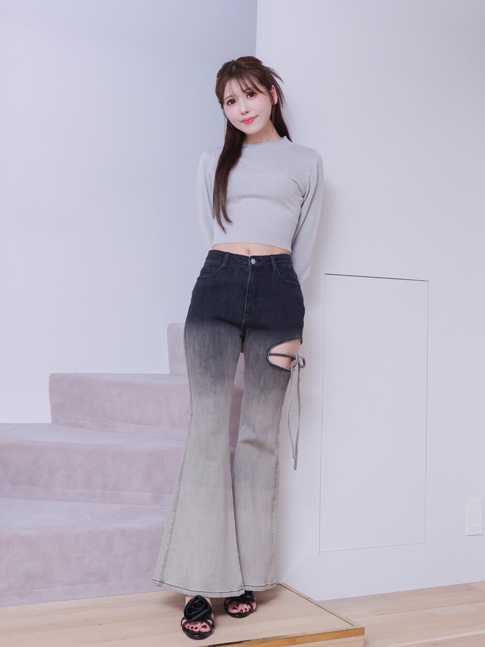 ブラック系のデニムパンツ、ブラック系のサンダル、グレー系のニット/セーターを着用したレディースの春コーディネートの2枚目の写真