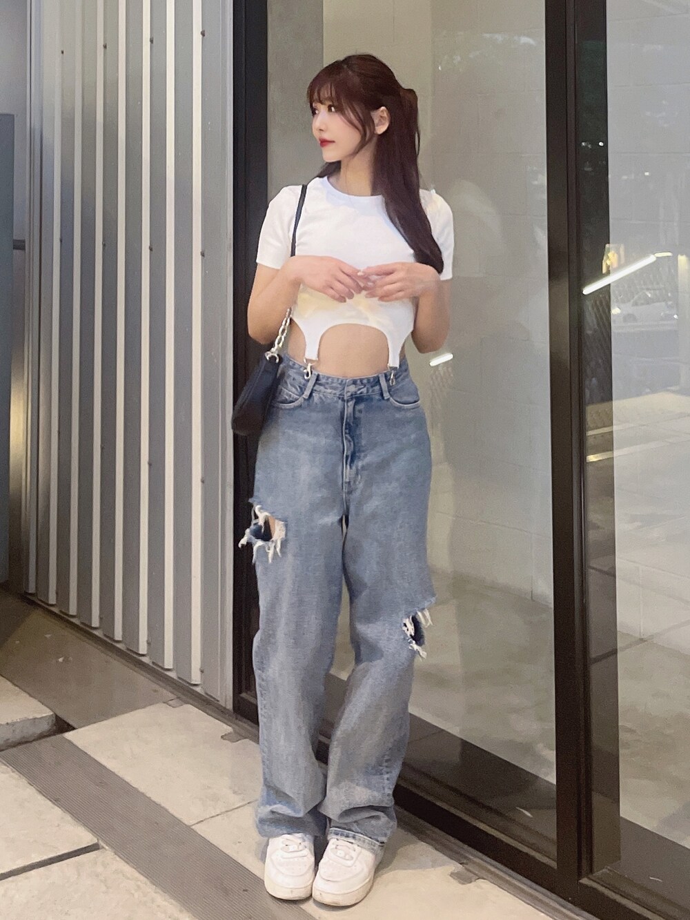 ブルー系のデニムパンツ、ホワイト系のTシャツ/カットソー、ブラック系のショルダーバッグを着用したレディースの春コーディネートの3枚目の写真