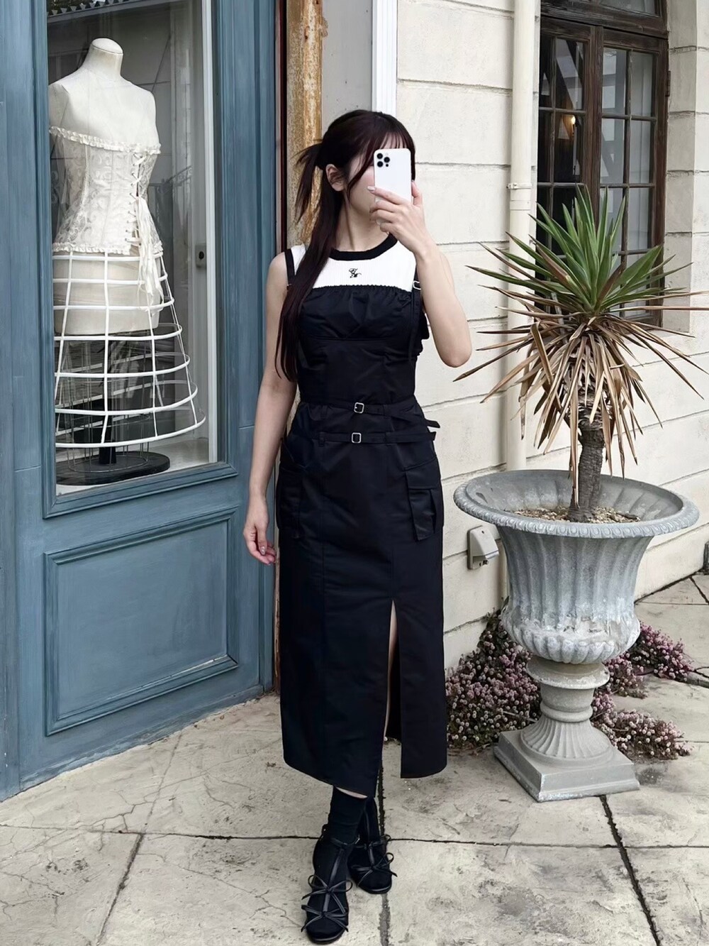 ブラック系のワンピース、ホワイト系のニット/セーター、ブラック系のサンダルを着用したレディースの夏コーディネートの6枚目の写真