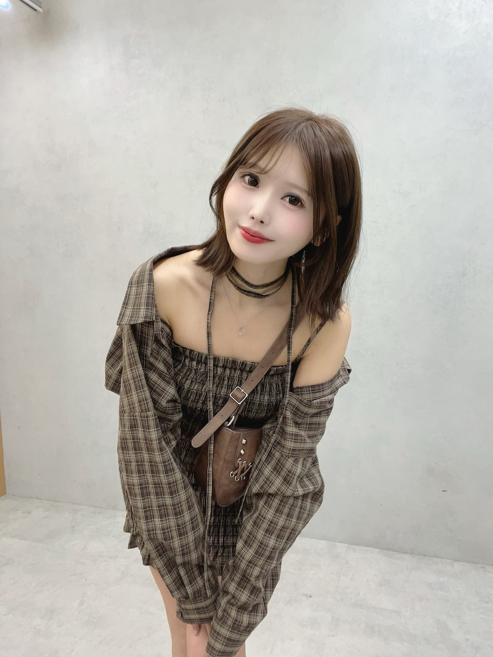 ブラウン系のワンピース、ブラウン系のショルダーバッグ、ホワイト系のブーツを着用したレディースの秋コーディネートの7枚目の写真