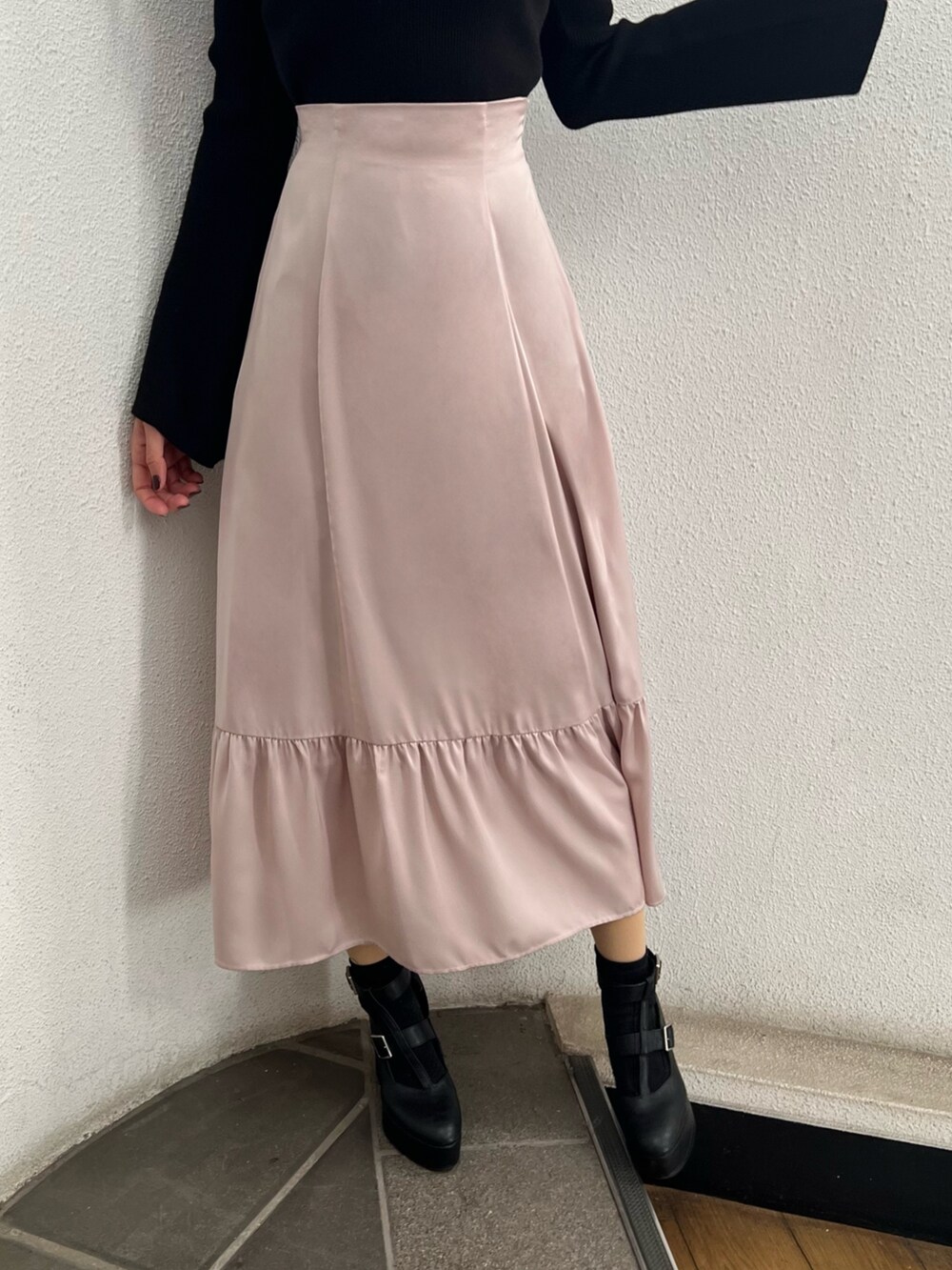 ブラック系のニット/セーター、ピンク系のスカート、ブラック系のショルダーバッグを着用したレディースの冬コーディネートの4枚目の写真