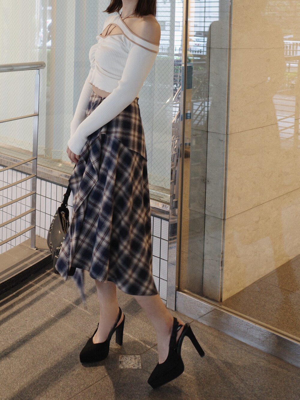 ホワイト系のTシャツ/カットソー、ブルー系のスカート、ブラック系のショルダーバッグを着用したレディースの秋コーディネートの4枚目の写真