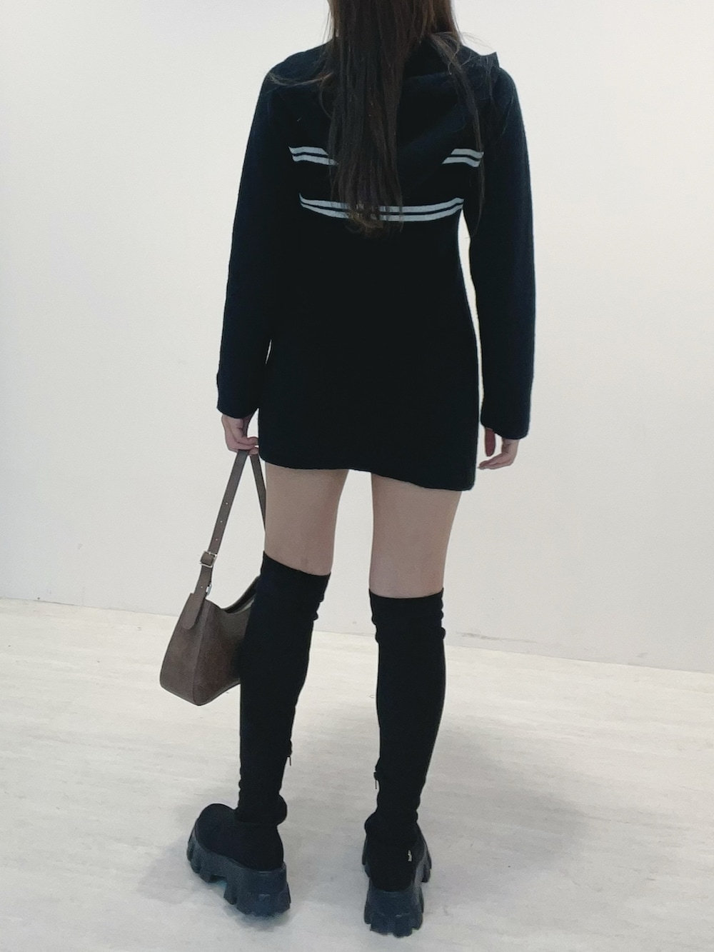 ブラック系のワンピース、ブラック系のブーツ、ブラウン系のショルダーバッグを着用したレディースの秋コーディネートの4枚目の写真