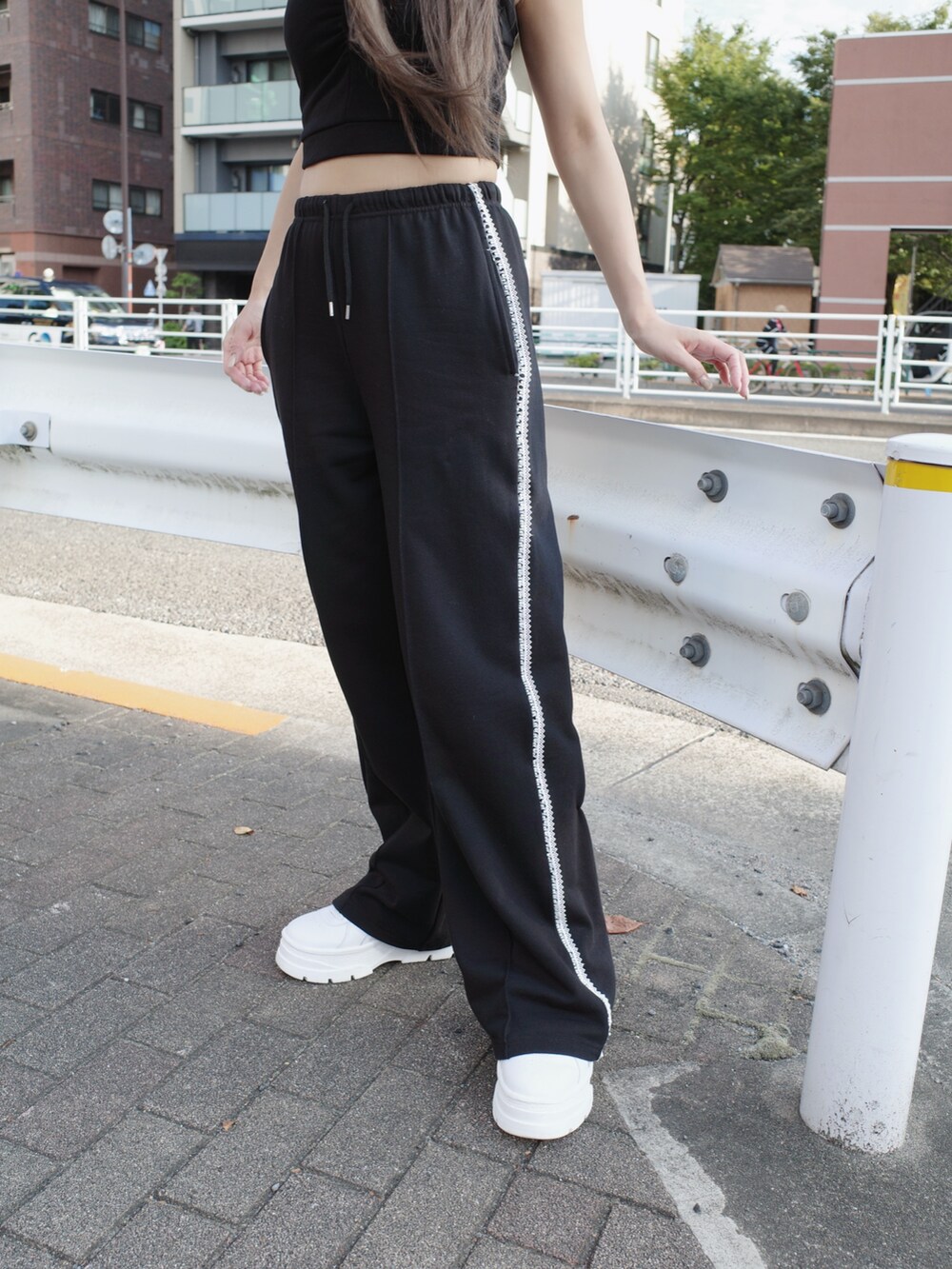 ブラック系のキャミソール、ブラック系のスウェットパンツ、ホワイト系のスニーカーを着用したレディースの夏コーディネートの6枚目の写真