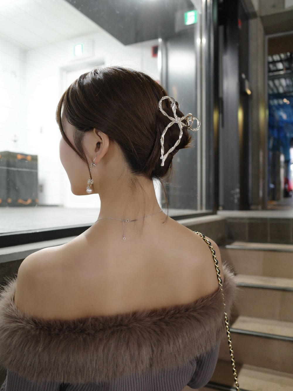 ブラウン系のワンピース、ブラック系のショルダーバッグ、ブラック系のブーツを着用したレディースの秋コーディネートの5枚目の写真