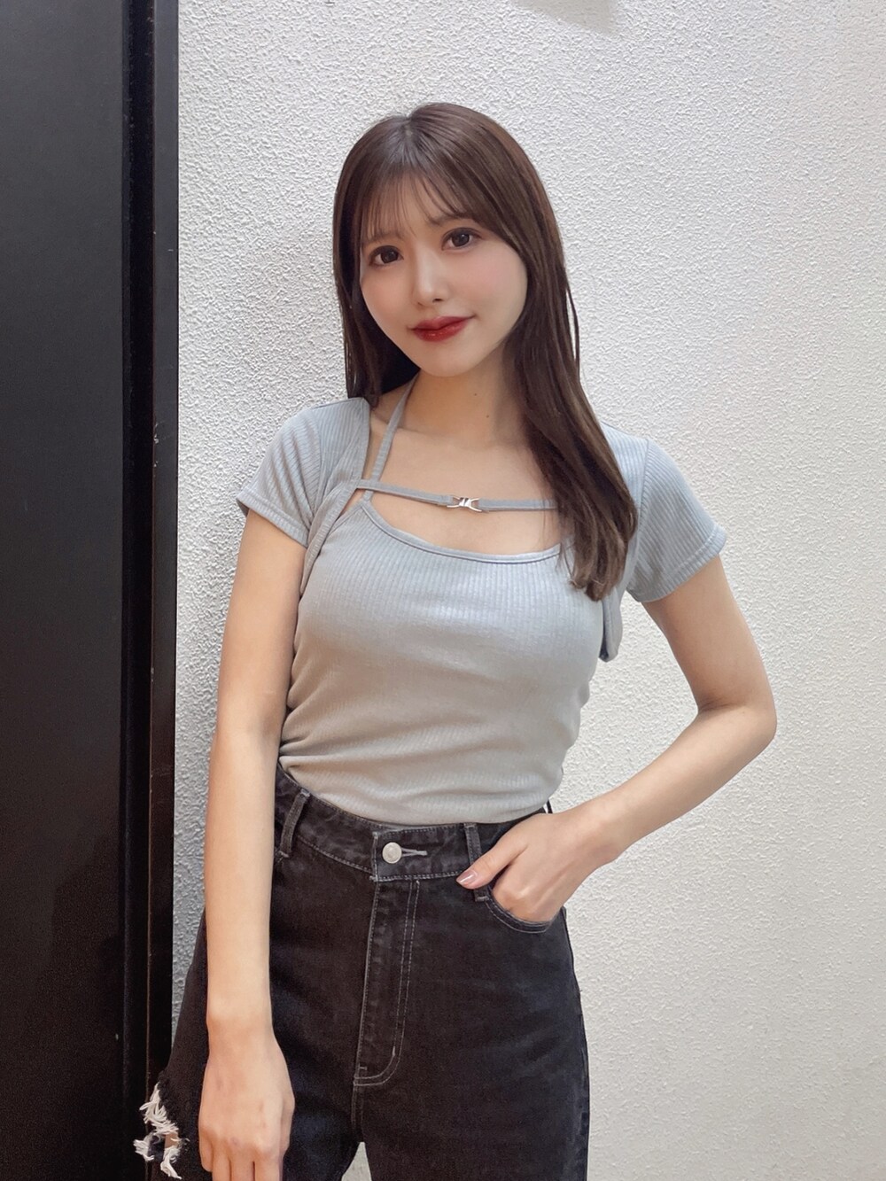 ブルー系のニット/セーター、ブラック系のデニムパンツ、ホワイト系のサンダルを着用したレディースの春コーディネートの4枚目の写真