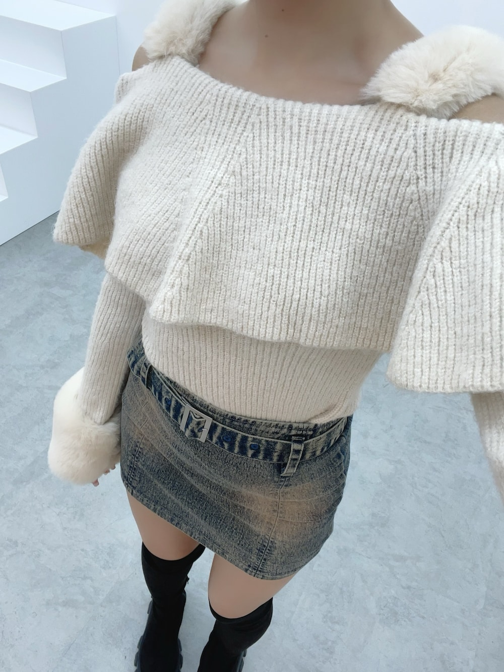 ホワイト系のニット/セーター、ブルー系のデニムスカート、ブラック系のブーツを着用したレディースの秋コーディネートの7枚目の写真