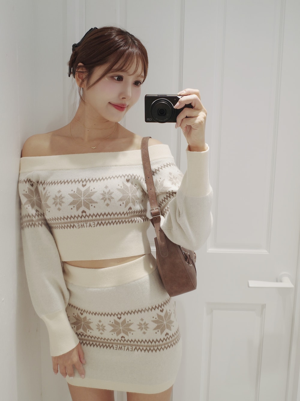 ホワイト系のニット/セーター、ホワイト系のスカート、ブラウン系のブーツを着用したレディースの秋コーディネートの8枚目の写真