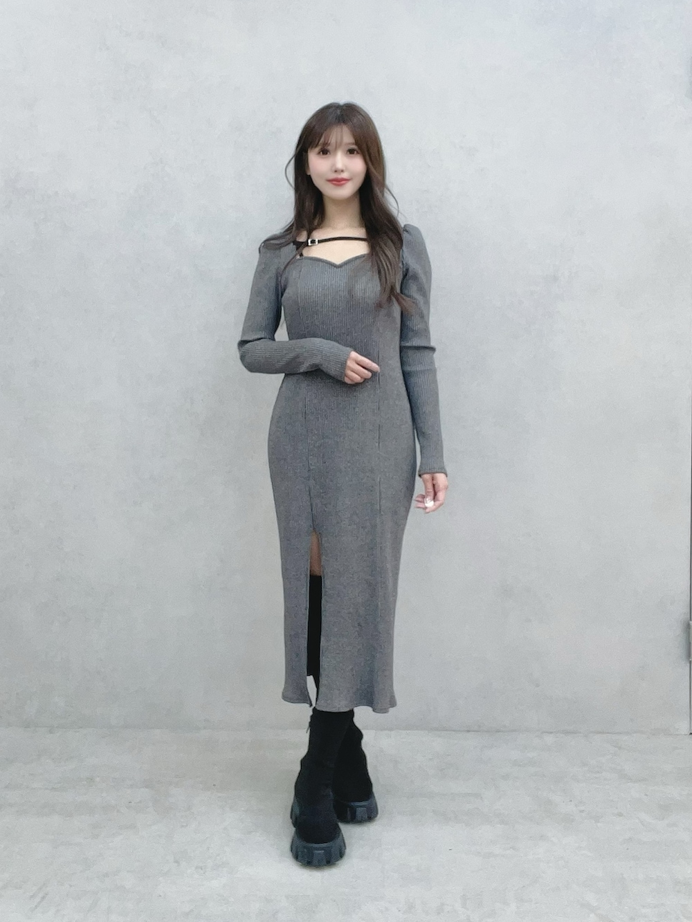 グレー系のワンピース、ブラック系のブーツを着用したレディースの冬コーディネートの3枚目の写真