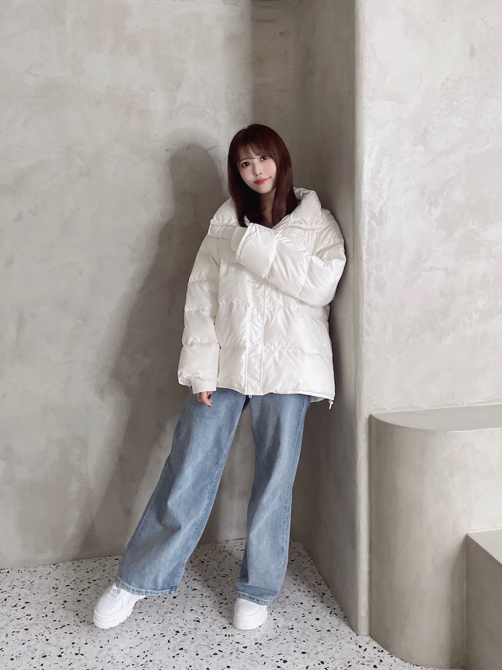 ホワイト系のダウンジャケット/コート、ブルー系のデニムパンツ、ホワイト系のスニーカーを着用したレディースの秋コーディネートの5枚目の写真