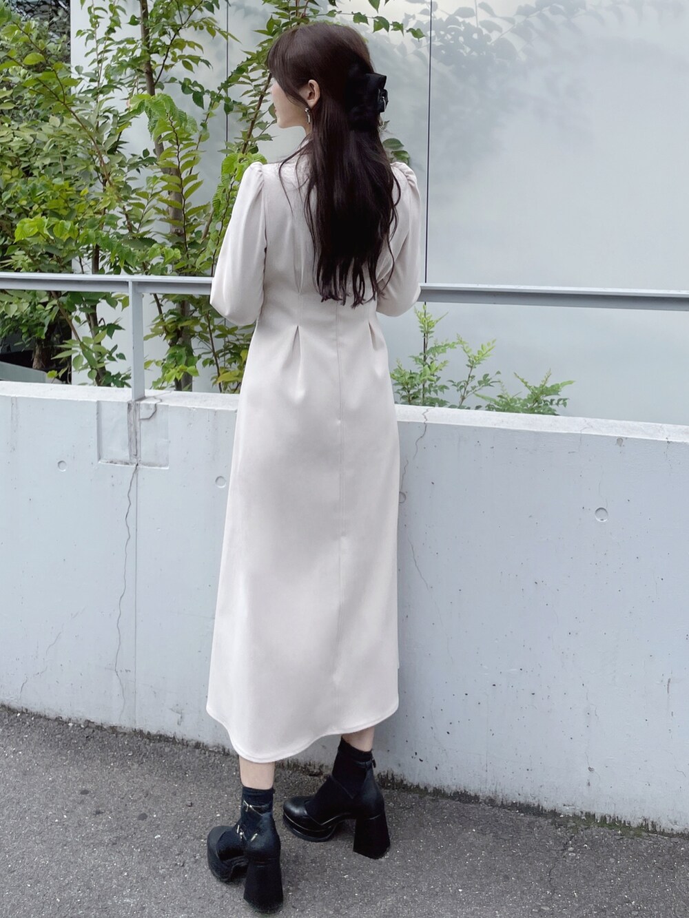 ホワイト系のワンピース、ブラック系のパンプス、ブラック系のピアス（両耳用）を着用したレディースの秋コーディネートの5枚目の写真