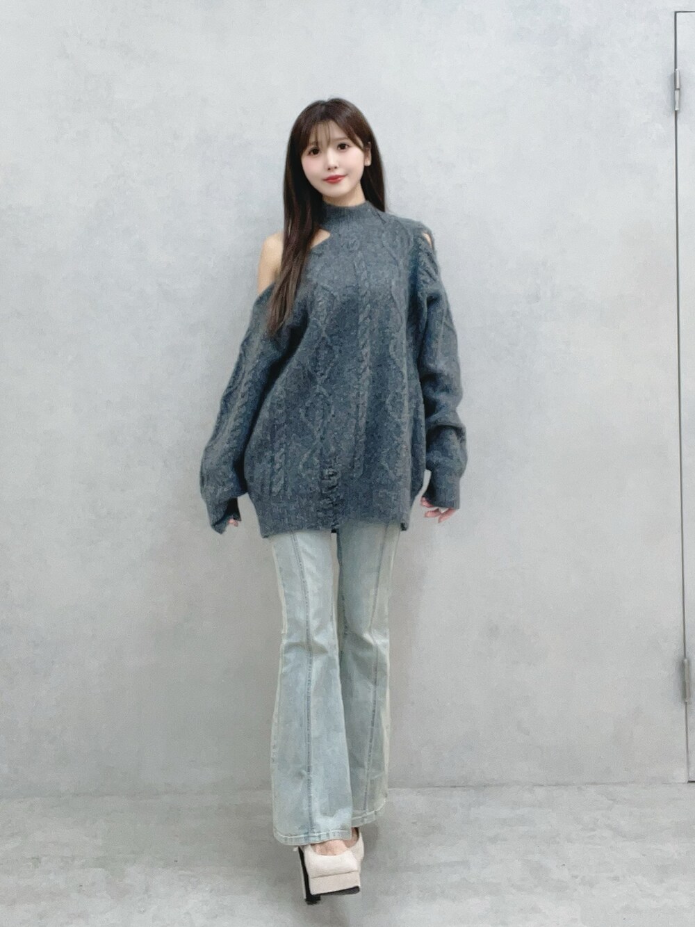 グレー系のニット/セーター、ブルー系のデニムパンツを着用したレディースの冬コーディネートの4枚目の写真