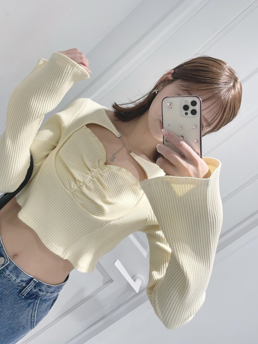 イエロー系のTシャツ/カットソー、ブルー系のデニムパンツ、ブラック系のボストンバッグを着用したレディースの冬コーディネートの8枚目の写真