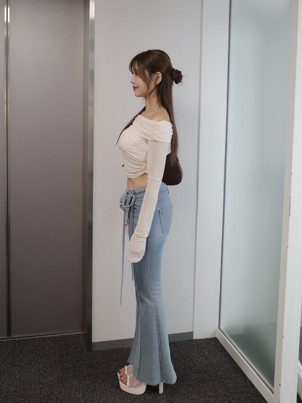 ホワイト系のTシャツ/カットソー、ブルー系のデニムパンツ、ホワイト系のサンダルを着用したレディースの春コーディネートの5枚目の写真