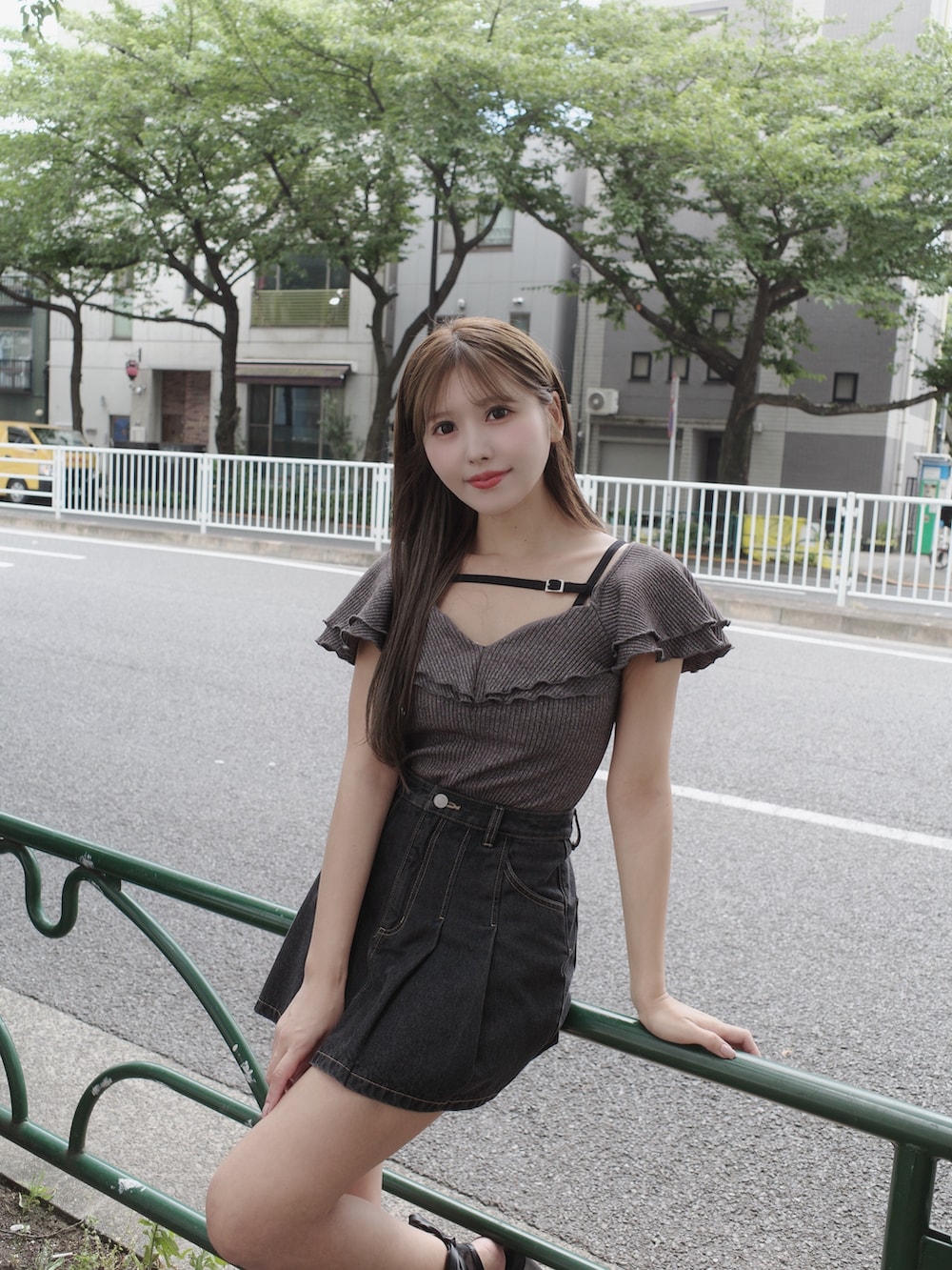 ブラック系のデニムスカート、ブラック系のサンダル、グレー系のTシャツ/カットソーを着用したレディースの夏コーディネートの6枚目の写真