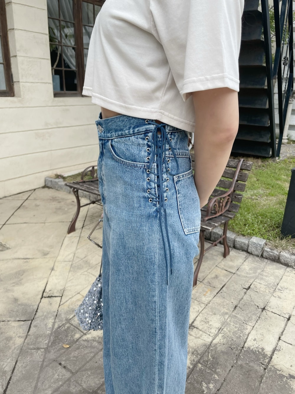 ブルー系のデニムパンツ、シルバー系のハンドバッグ、ホワイト系のTシャツ/カットソーを着用したレディースの春コーディネートの8枚目の写真