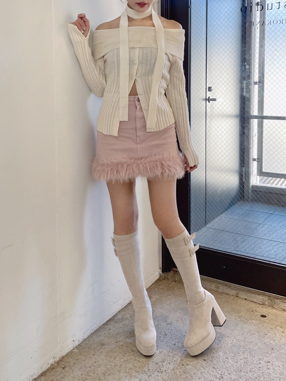 ホワイト系のニット/セーター、ホワイト系のブーツ、ピンク系のデニムスカートを着用したレディースの秋コーディネートの5枚目の写真