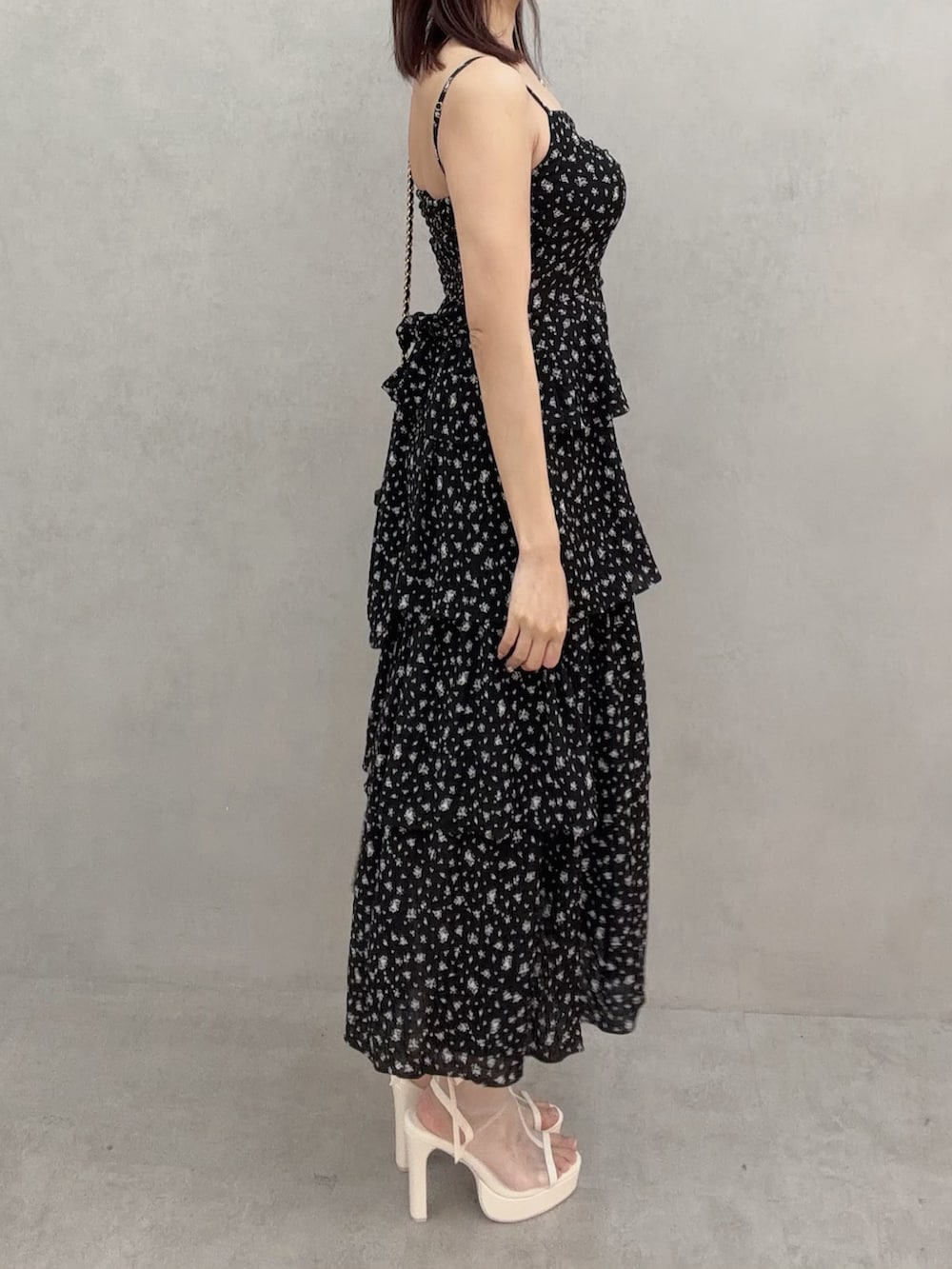 ホワイト系のサンダル、ブラック系のワンピース、ブラック系のハンドバッグを着用したレディースの冬コーディネートの4枚目の写真