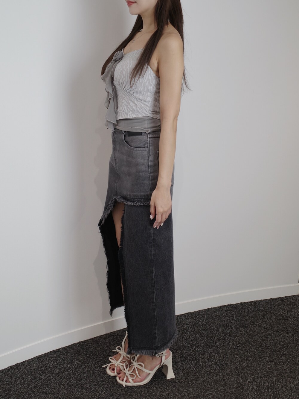 ブラック系のデニムスカート、ホワイト系のサンダル、グレー系のキャミソールを着用したレディースの夏コーディネートの7枚目の写真