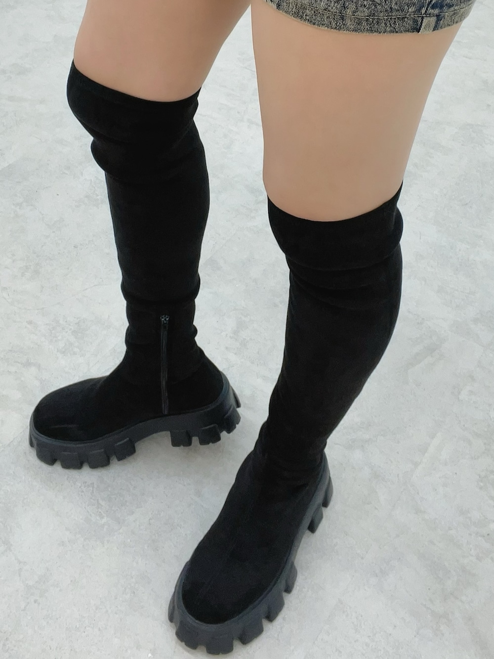 ホワイト系のニット/セーター、ブルー系のデニムスカート、ブラック系のブーツを着用したレディースの秋コーディネートの9枚目の写真