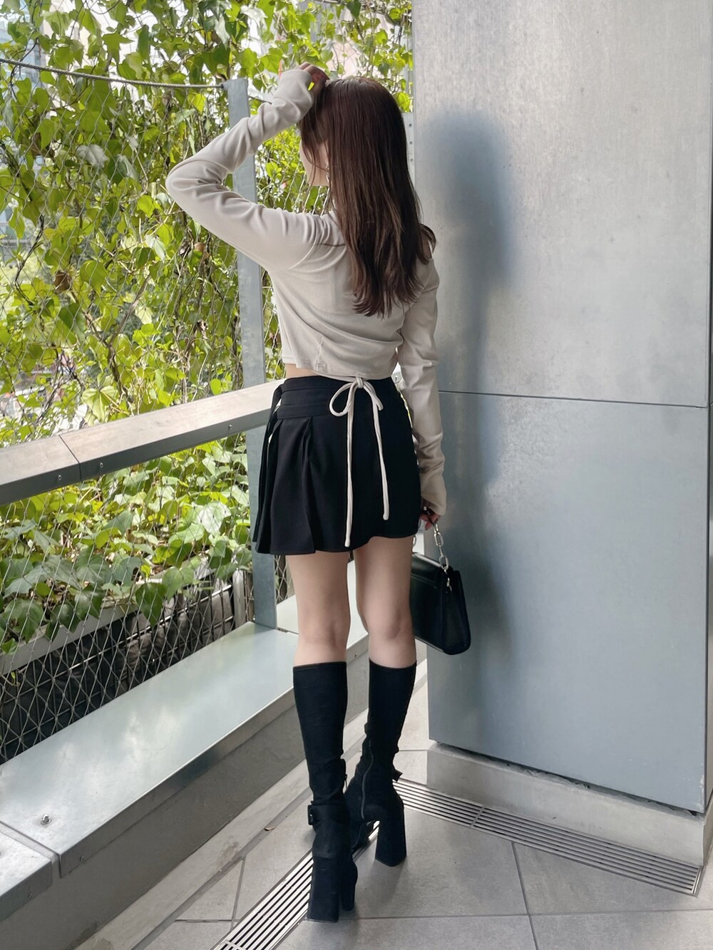 ホワイト系のTシャツ/カットソー、ブラック系のショルダーバッグ、ブラック系のスカートを着用したレディースの秋コーディネートの7枚目の写真