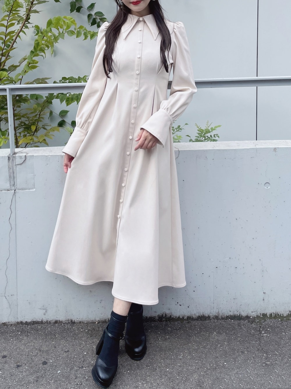 ホワイト系のワンピース、ブラック系のパンプス、ブラック系のピアス（両耳用）を着用したレディースの秋コーディネートの4枚目の写真