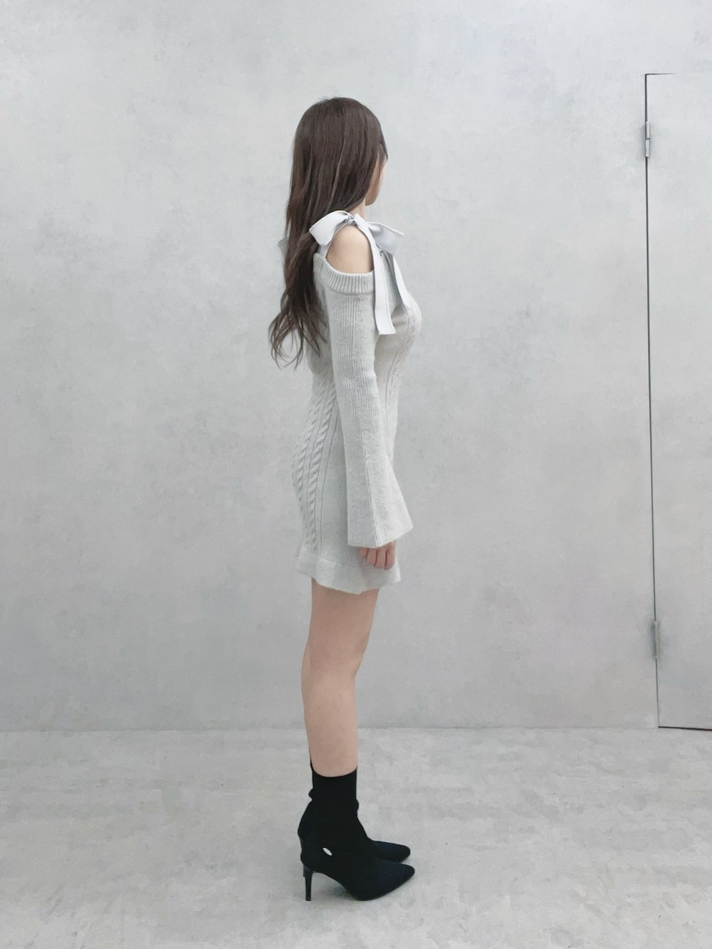 グレー系のワンピース、ブラック系のブーツを着用したレディースの冬コーディネートの3枚目の写真