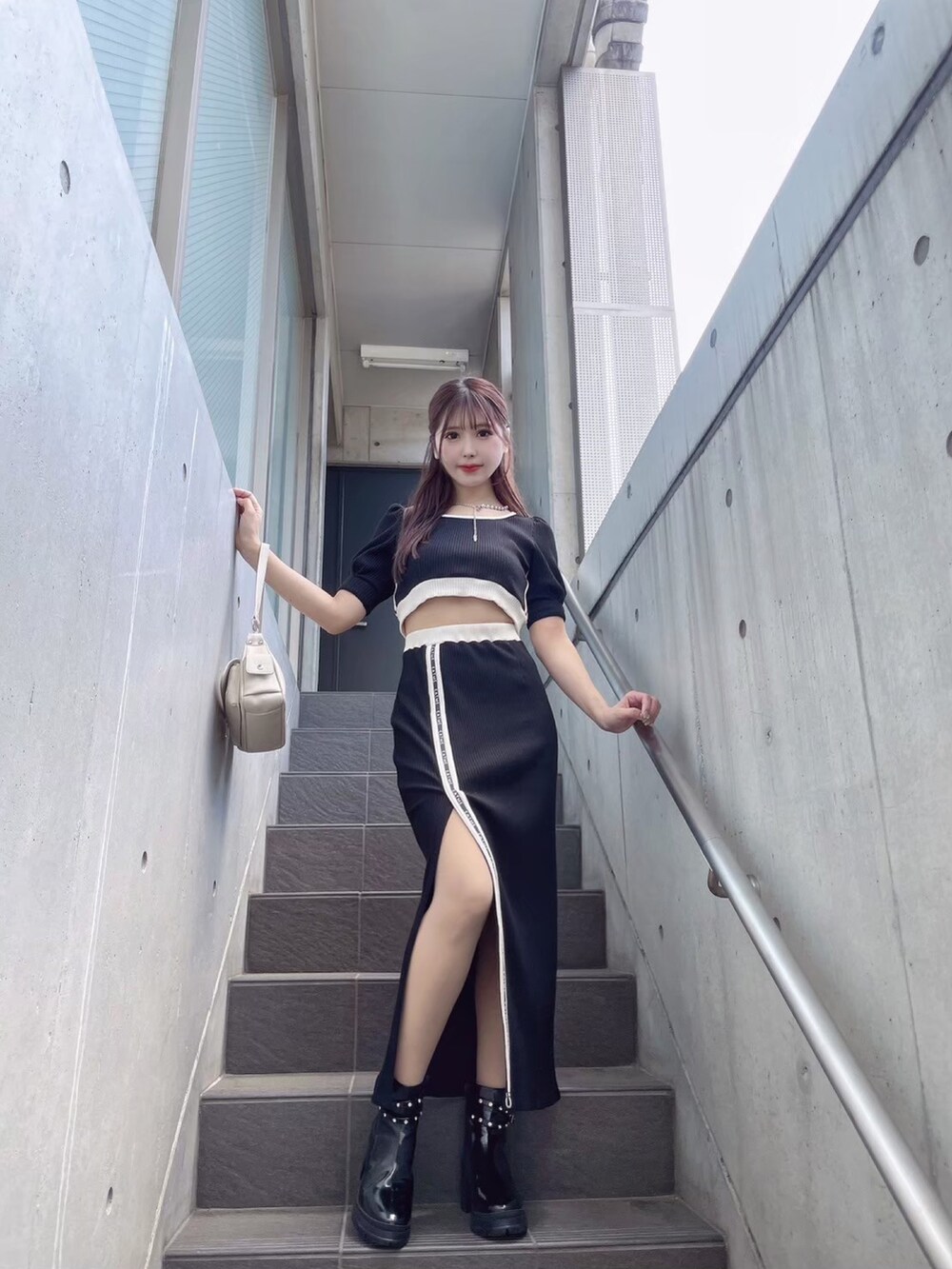 ブラック系のTシャツ/カットソー、ブラック系のスカート、ホワイト系のショルダーバッグを着用したレディースの秋コーディネートの4枚目の写真