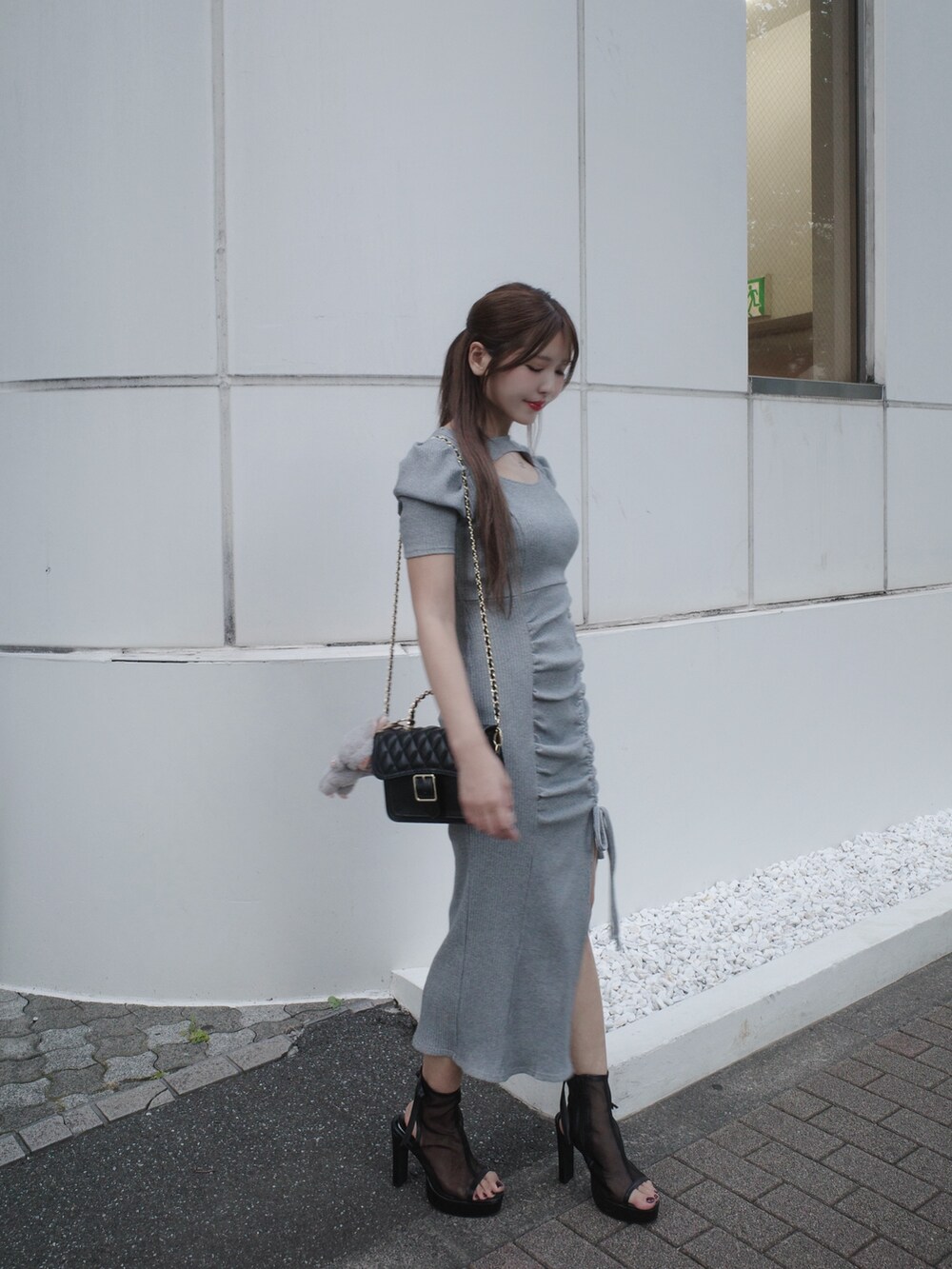 グレー系のワンピース、ブラック系のサンダルを着用したレディースの夏コーディネートの2枚目の写真
