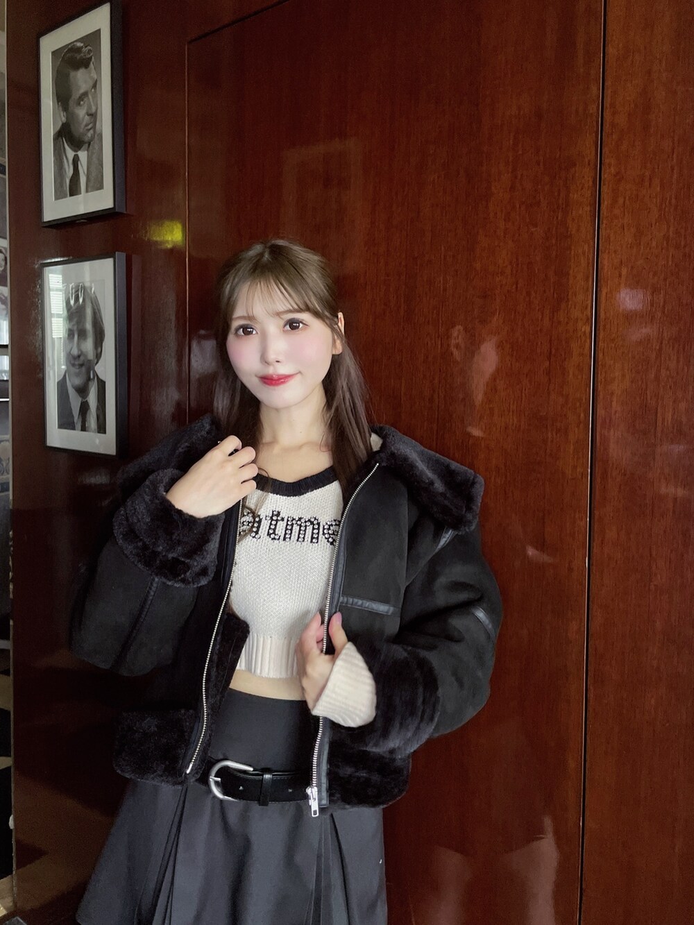 ブラック系のブルゾン、グレー系のスカート、ホワイト系のニット/セーターを着用したレディースの冬コーディネートの6枚目の写真