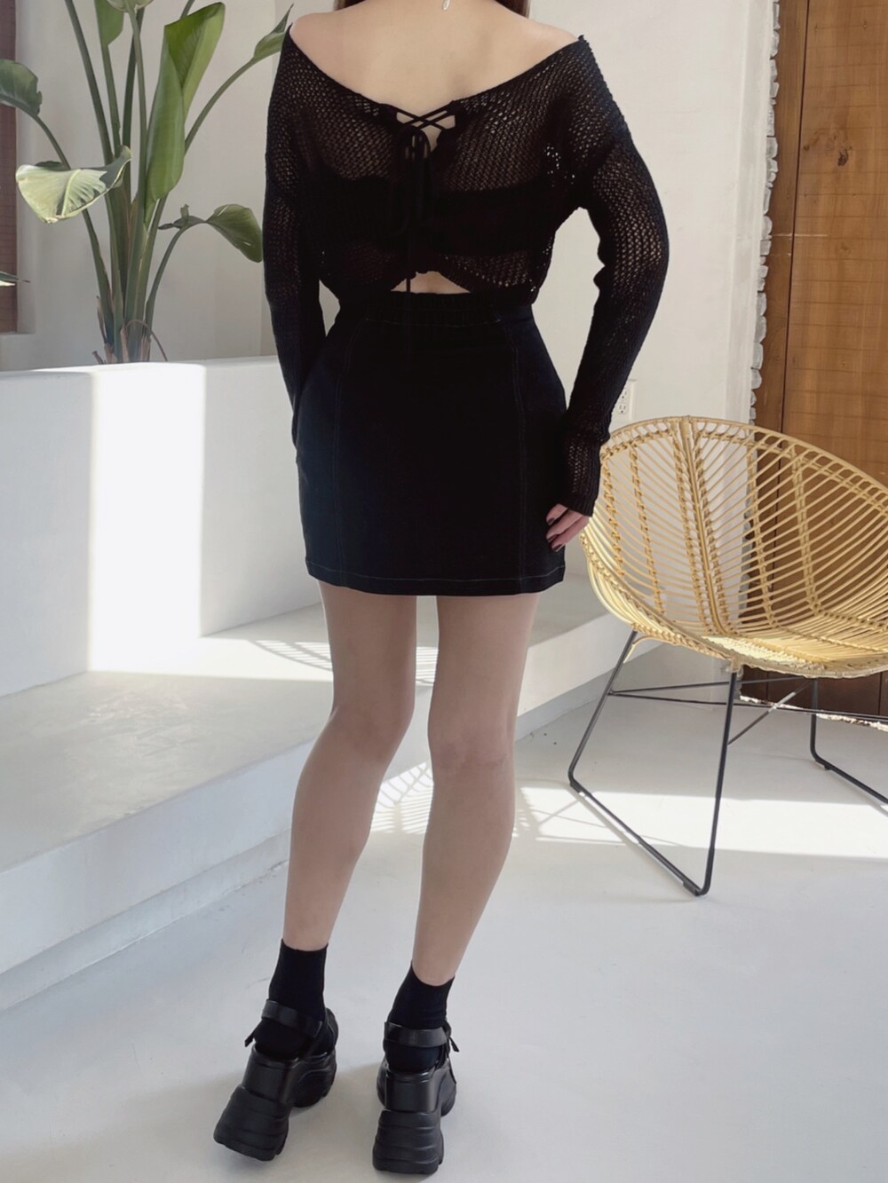 ブラック系のデニムスカート、ブラック系のサンダル、ブラック系のニット/セーターを着用したレディースの冬コーディネートの8枚目の写真