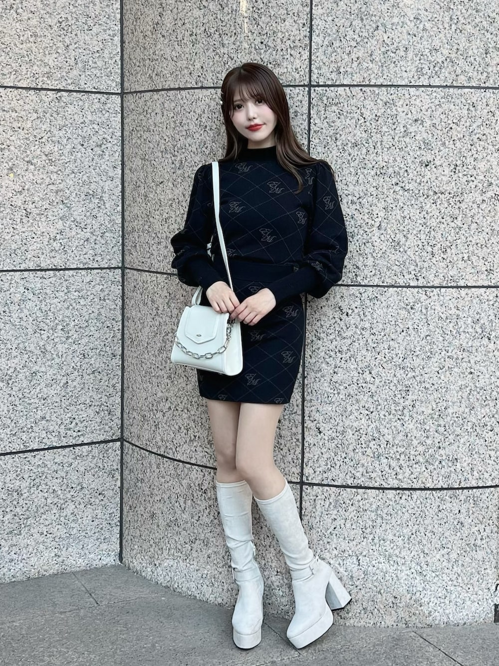 ブラック系のニット/セーター、ホワイト系のブーツ、ブラック系のスカートを着用したレディースの秋コーディネートの4枚目の写真