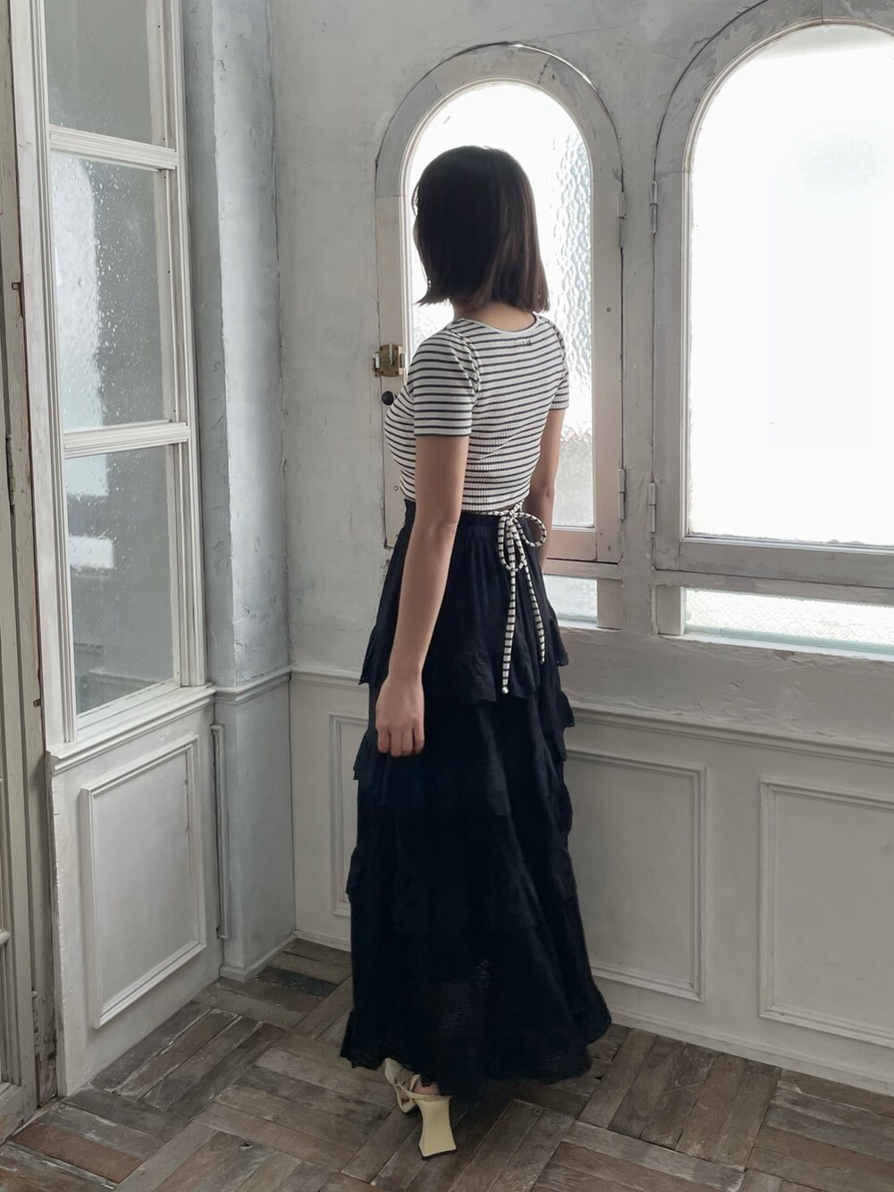 ブラック系のスカート、イエロー系のパンプス、その他のTシャツ/カットソーを着用したレディースの春コーディネートの3枚目の写真