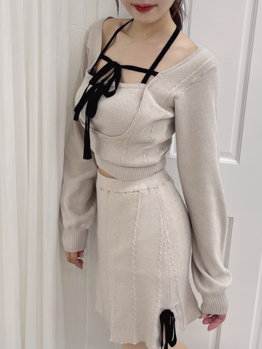 グレー系のニット/セーター、グレー系のスカートを着用したレディースの夏コーディネートの2枚目の写真