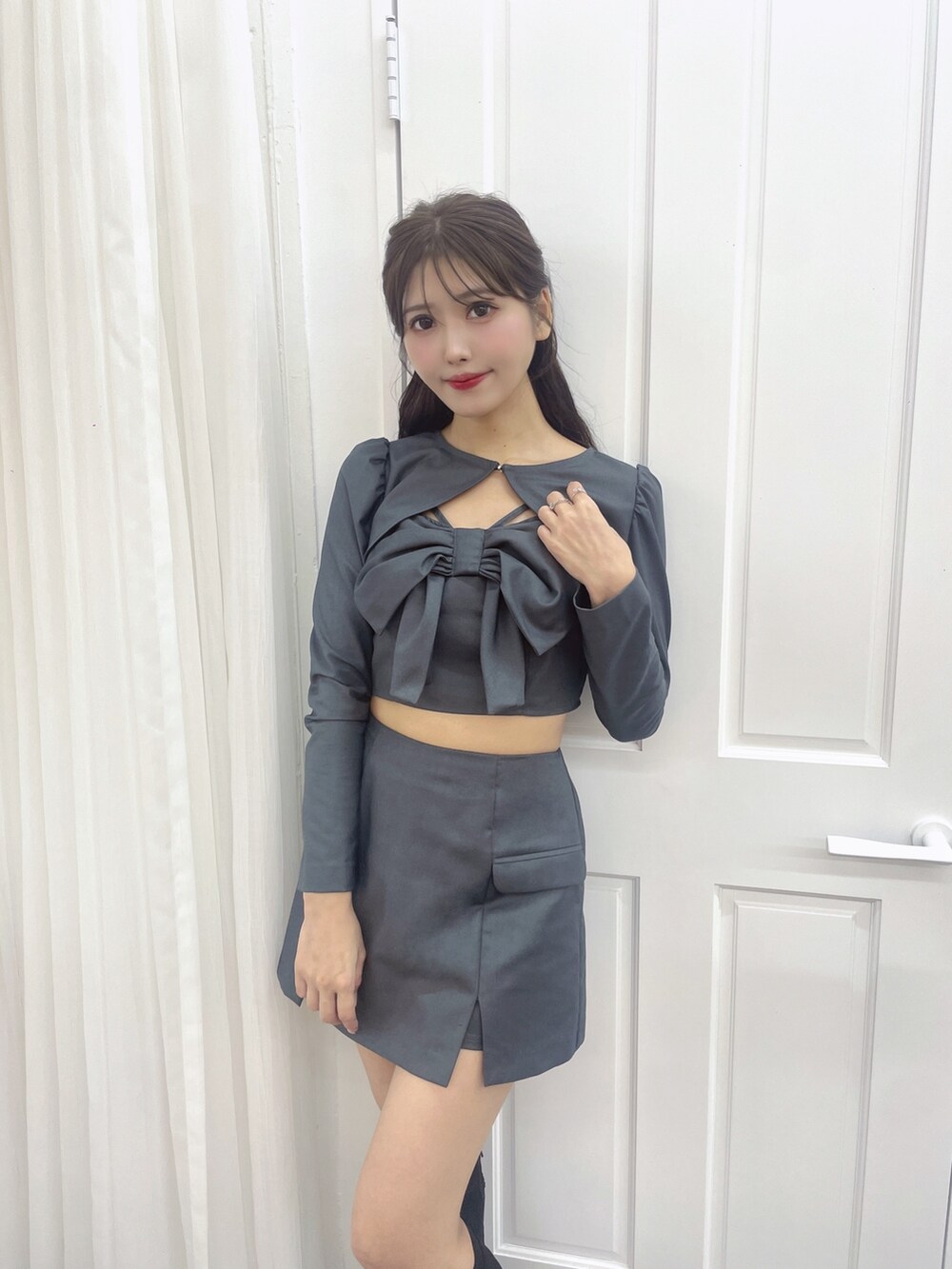 グレー系のワンピース、ブラック系のブーツを着用したレディースの秋コーディネートの4枚目の写真