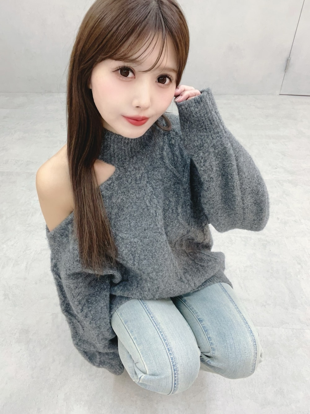 グレー系のニット/セーター、ブルー系のデニムパンツを着用したレディースの冬コーディネートの8枚目の写真