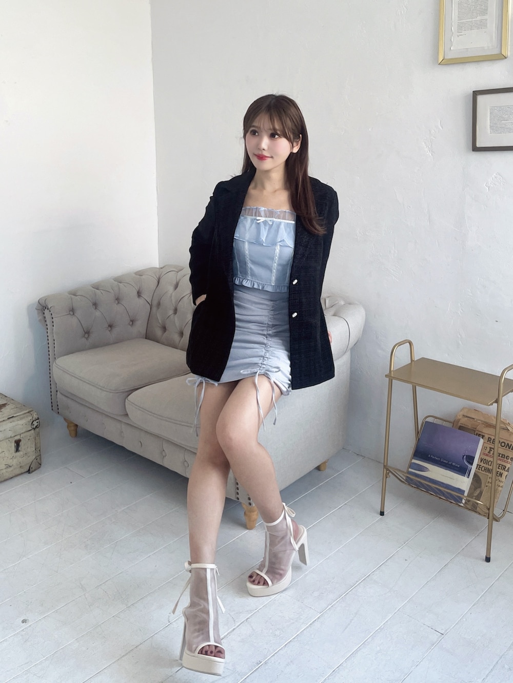 ブルー系のキャミソール、ブラック系のテーラードジャケット、ブルー系のスカートを着用したレディースの春コーディネートの2枚目の写真