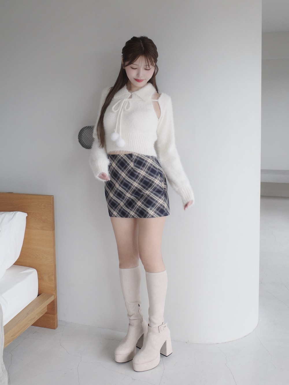 ホワイト系のニット/セーター、ブルー系のスカート、ホワイト系のブーツを着用したレディースの秋コーディネートの2枚目の写真