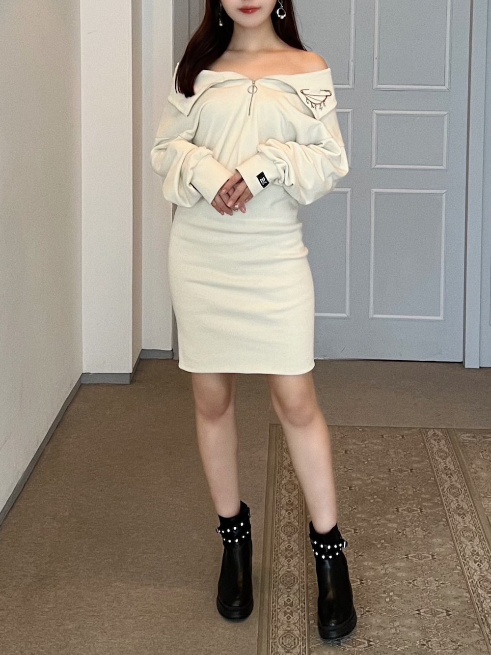 ホワイト系のワンピース、ブラック系のブーツ、シルバー系のブローチ/コサージュを着用したレディースの秋コーディネートの7枚目の写真