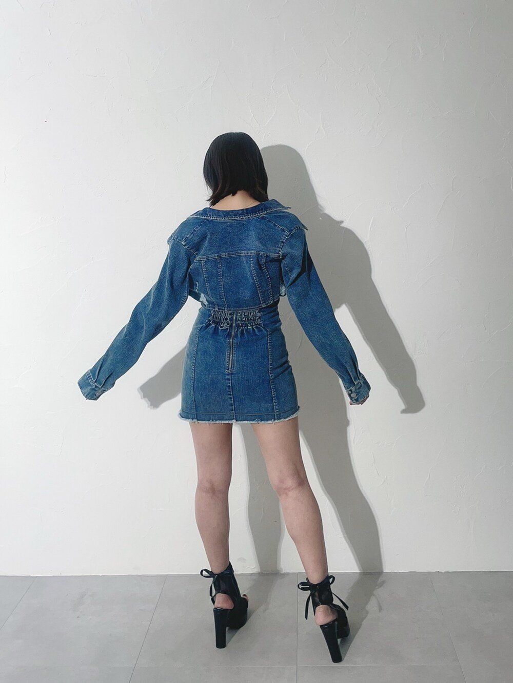 ブラック系のサンダル、ブルー系のワンピースを着用したレディースの春コーディネートの6枚目の写真