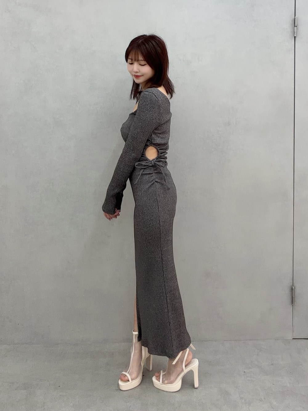 グレー系のワンピース、ホワイト系のサンダルを着用したレディースの冬コーディネートの3枚目の写真