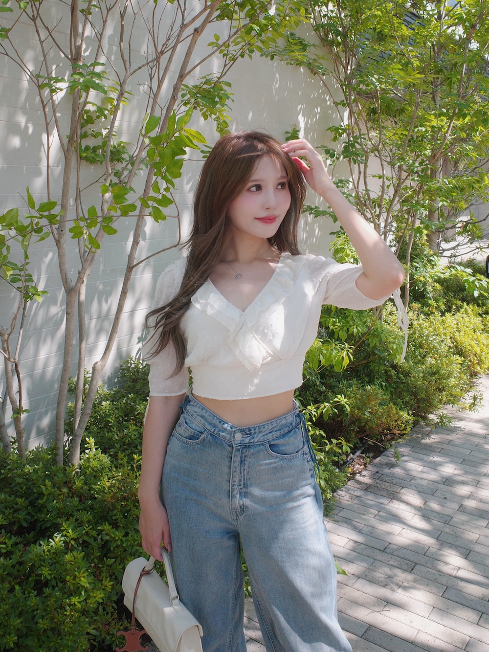 ホワイト系のシャツ/ブラウス、ブルー系のデニムパンツを着用したレディースの夏コーディネートの2枚目の写真