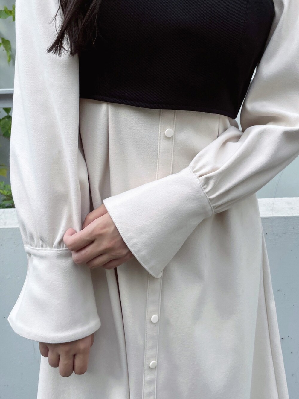 ホワイト系のワンピース、ブラック系のパンプス、ブラック系のピアス（両耳用）を着用したレディースの秋コーディネートの7枚目の写真