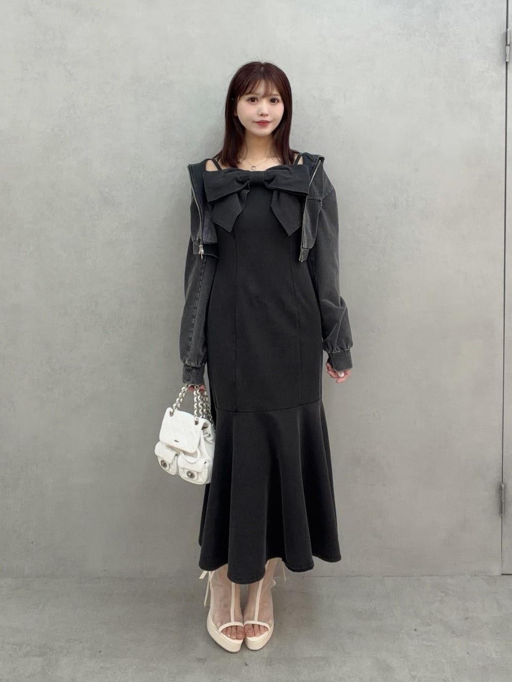 ブラック系のワンピース、ホワイト系のサンダル、ホワイト系のバックパック/リュックを着用したレディースの冬コーディネートの2枚目の写真