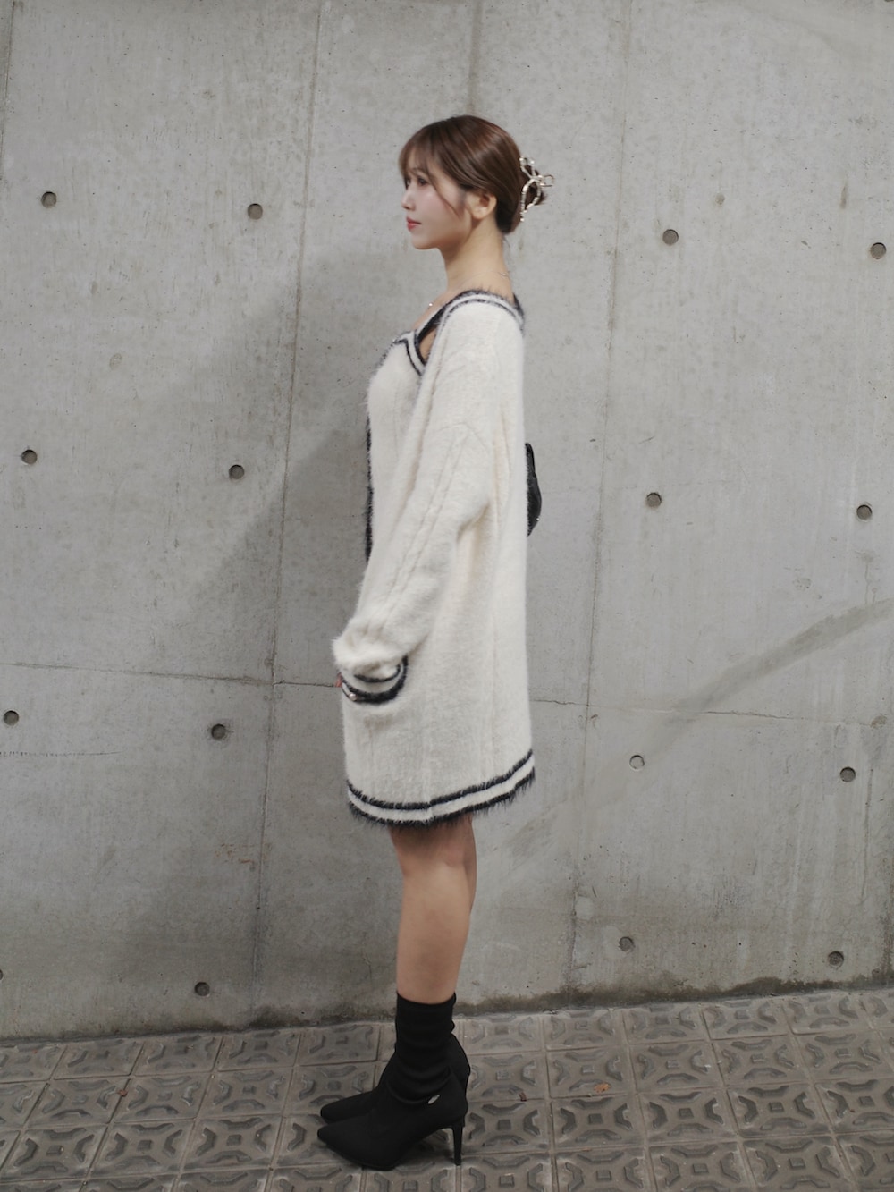 ホワイト系のワンピース、ブラック系のブーツ、ブラック系のハンドバッグを着用したレディースの秋コーディネートの6枚目の写真