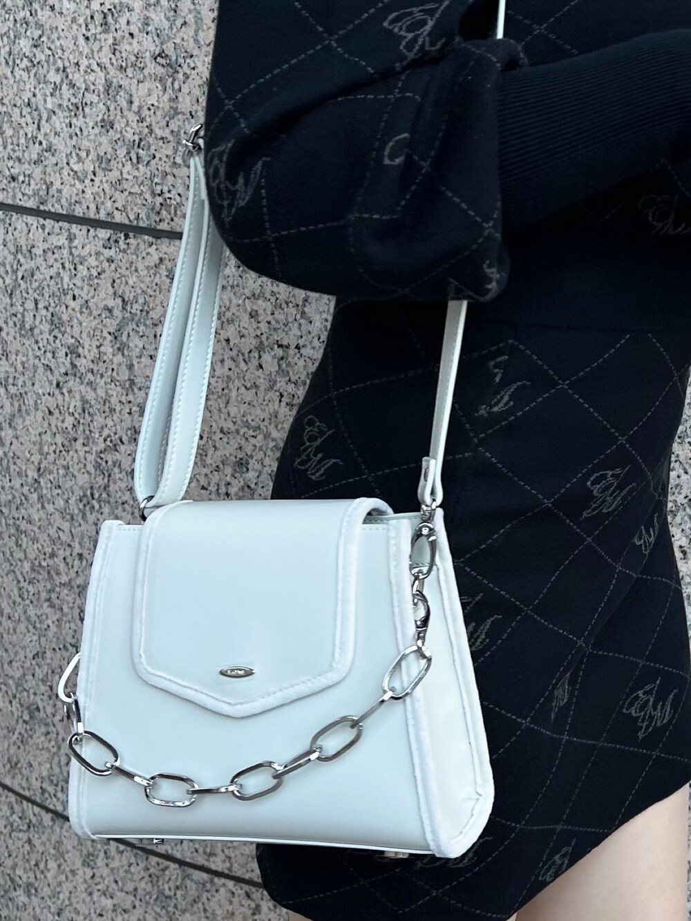 ブラック系のニット/セーター、ホワイト系のブーツ、ブラック系のスカートを着用したレディースの秋コーディネートの6枚目の写真