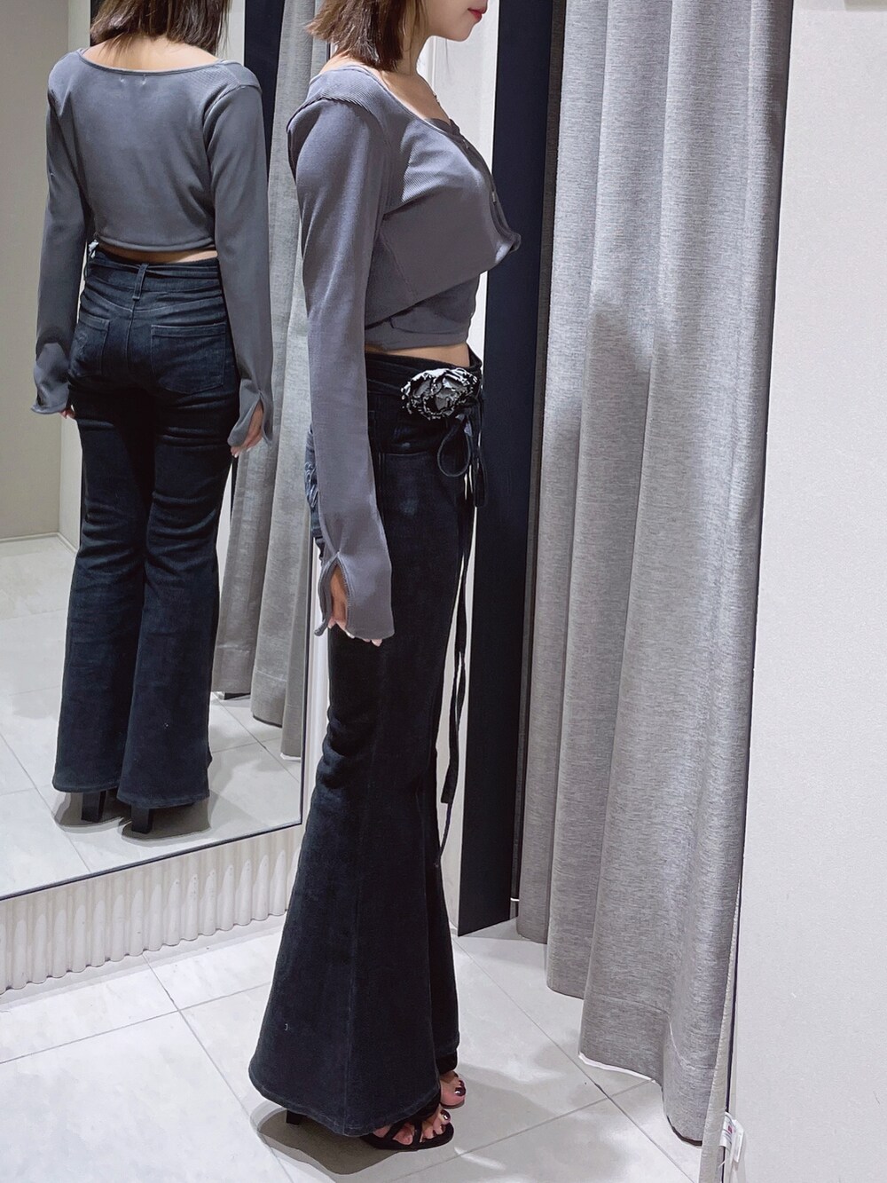 グレー系のTシャツ/カットソー、ブラック系のデニムパンツ、ブラック系のサンダルを着用したレディースの春コーディネートの5枚目の写真